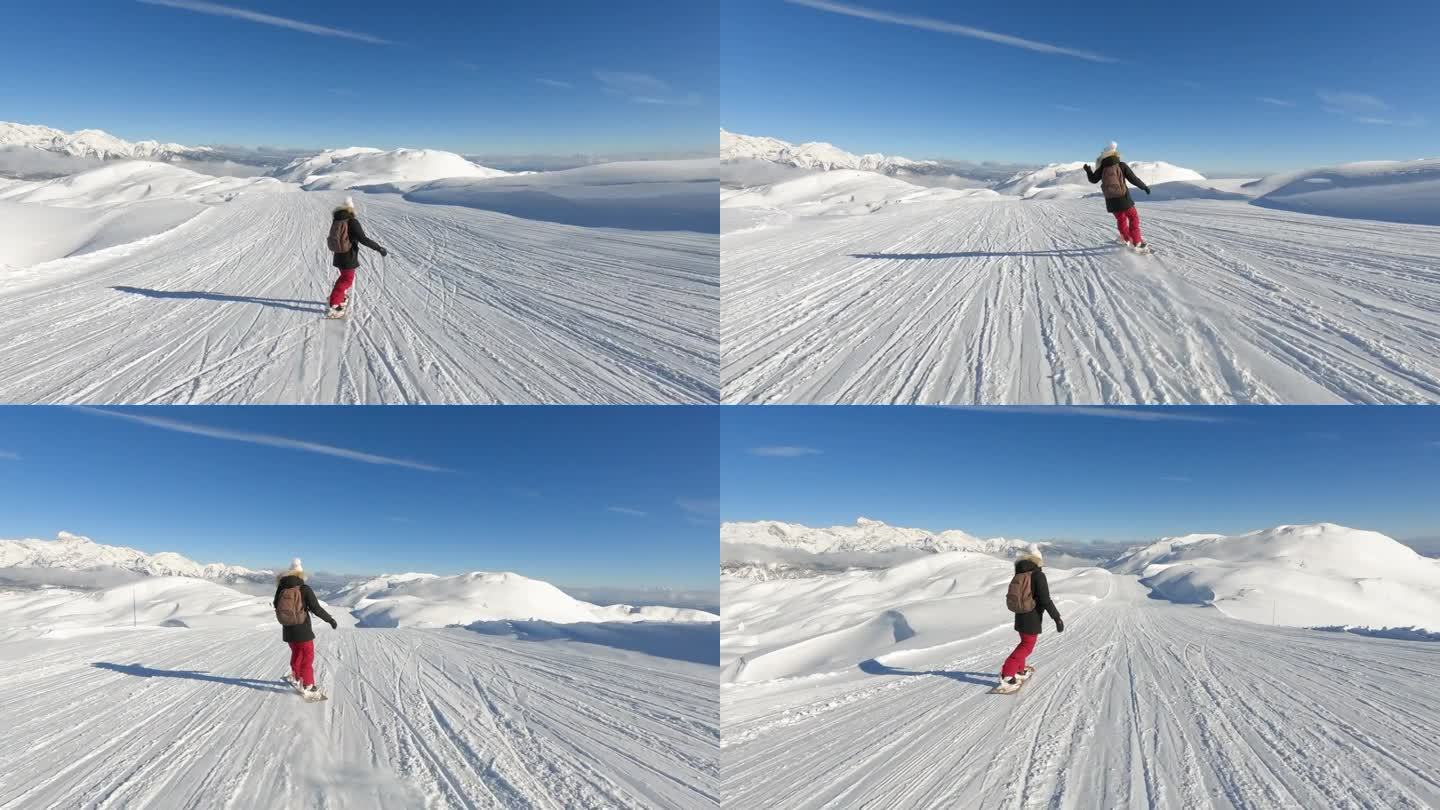 女士滑雪板在一个风景优美的滑雪斜坡与雪山的壮丽景色