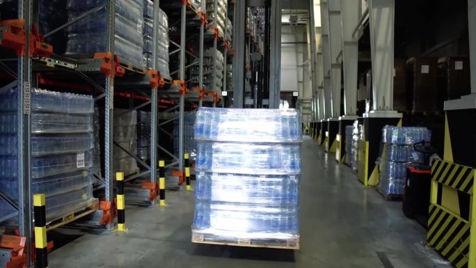 装货工人在现代仓库库存录像中把硬纸板箱装在托盘上的工作