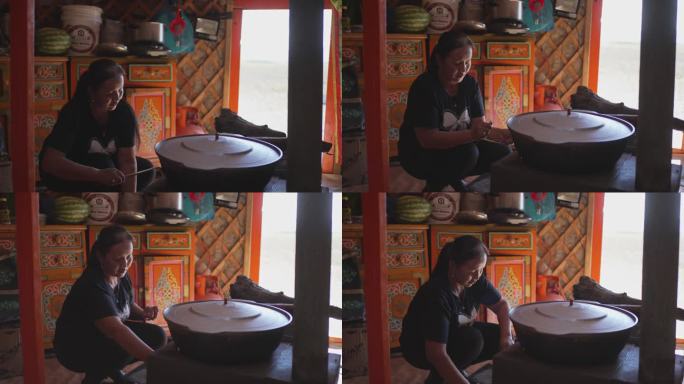 蒙古包内蒙古族牧民妇女为客人准备奶茶