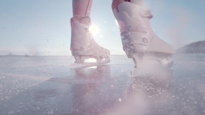 镜头光晕，超级慢动作，特写:当女士打开她的冰鞋时，冰块飞了起来