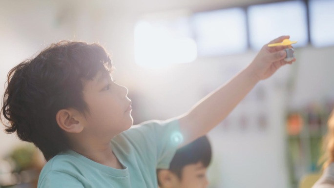 小男孩在教室里专心做科学实验的特写。