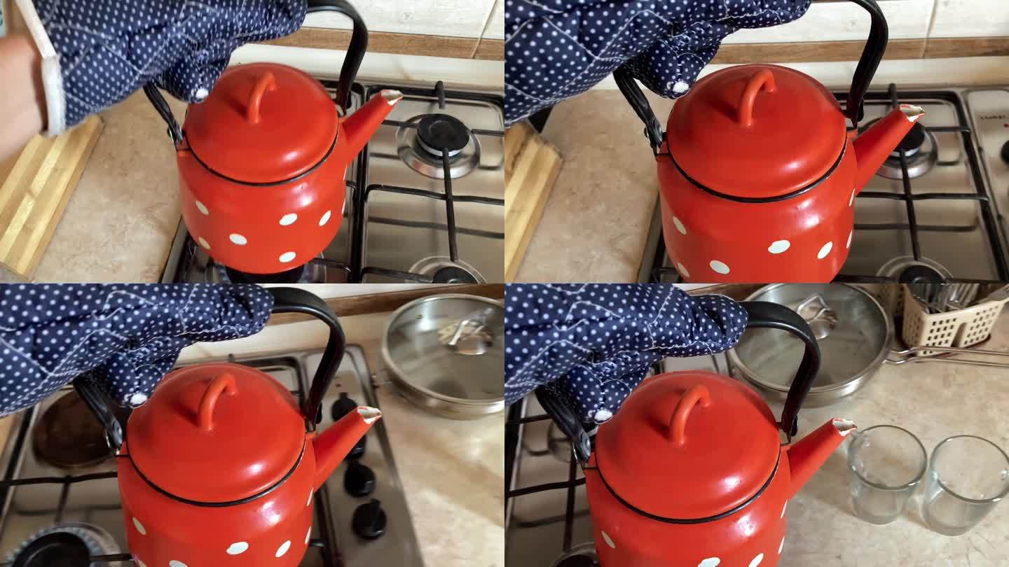 手拿茶壶拿老红茶壶。老式厨房的玻璃杯