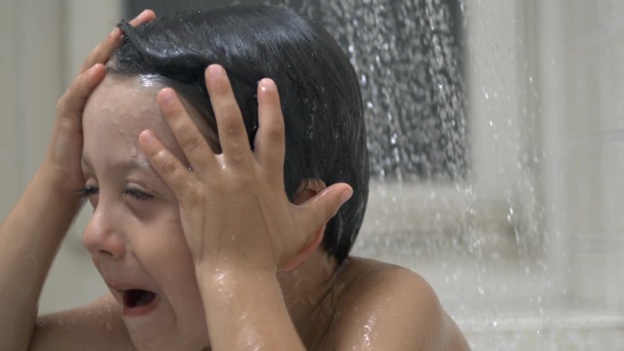 烦恼的孩子在800帧/秒的慢动作下淋浴的瀑布，小男孩的不满情绪在水滴下流淌