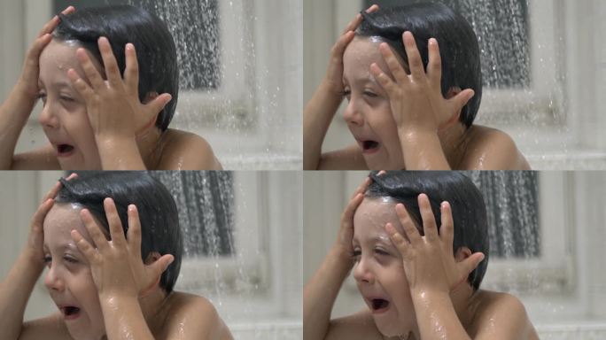 烦恼的孩子在800帧/秒的慢动作下淋浴的瀑布，小男孩的不满情绪在水滴下流淌