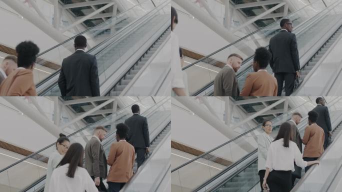 商务团队在现代机场大楼的自动扶梯上向上移动的慢动作