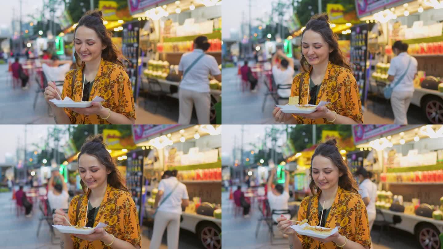 度假期间，一名女子在曼谷夜市吃泰国煎饼(roti)