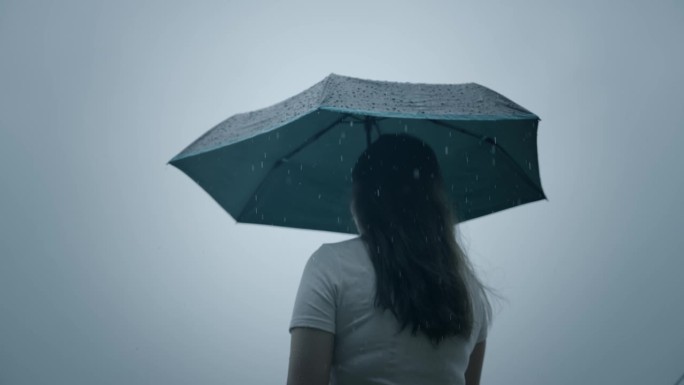 一个女人在雨中打着伞