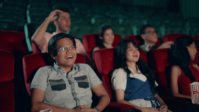 年轻情侣在电影院看电影——浪漫的约会之夜。