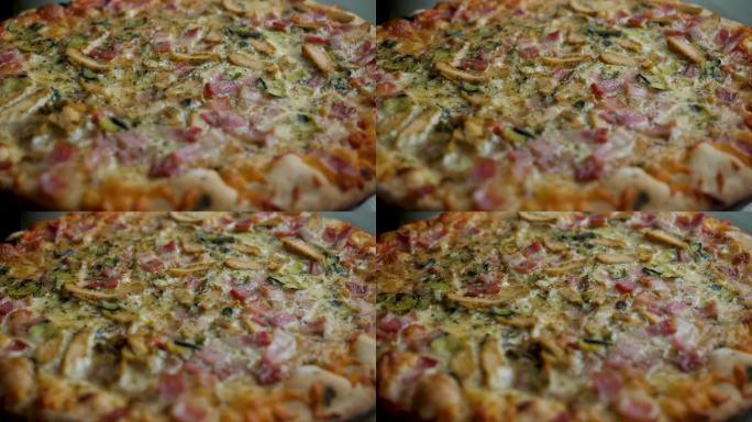 新鲜准备的披萨特写。披萨配马苏里拉芝士，培根，鸡肉，番茄，胡椒，香料，蘑菇和新鲜罗勒。火腿蘑菇自制披