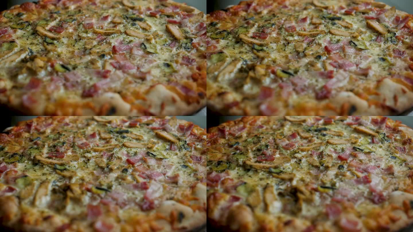 新鲜准备的披萨特写。披萨配马苏里拉芝士，培根，鸡肉，番茄，胡椒，香料，蘑菇和新鲜罗勒。火腿蘑菇自制披