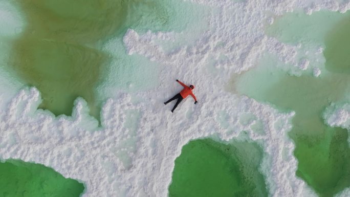 航拍男人躺在青海茫崖翡翠湖的盐池中
