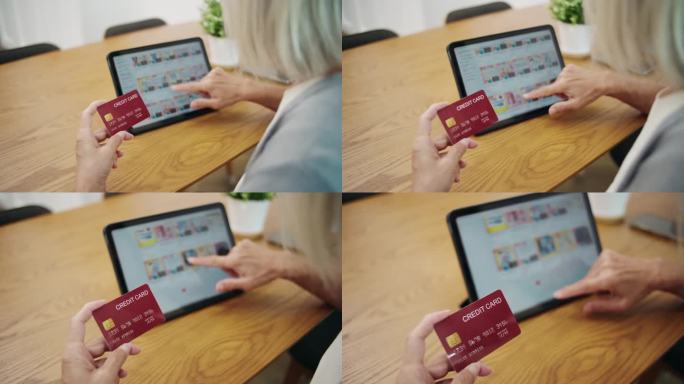 老妇人用数码平板电脑和信用卡购物