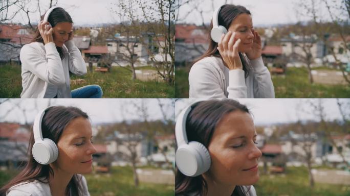 一个安静的女人戴着耳机在公园里听音乐
