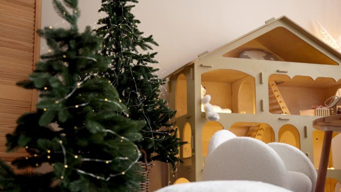 孩子们的房间里充满了新年的气氛。圣诞树旁边有一个玩具屋，还有一张儿童桌椅。儿童游戏领域和圣诞奇迹与新