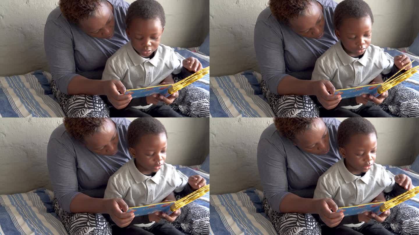非洲农村教育。非洲黑人妇女在家教育她可爱的小儿子