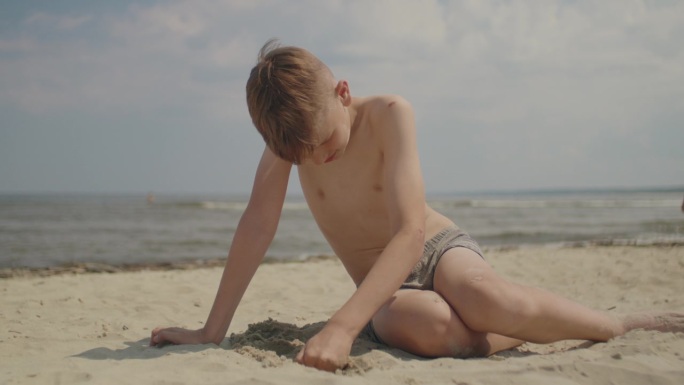 男孩在沙滩上玩沙子