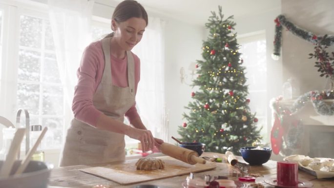 动态荷兰视角:美丽女人准备面团制作姜饼的电影慢动作。慈爱的母亲在圣诞节为她的家人准备糕点