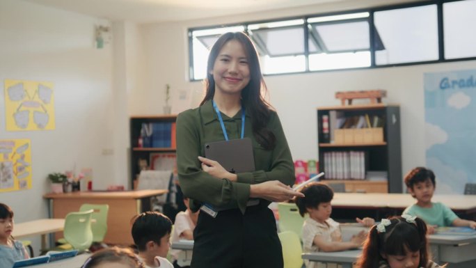 腰部向上的照片，前景的焦点是女老师对着镜头微笑，背景是坐在书桌前的年轻学生。