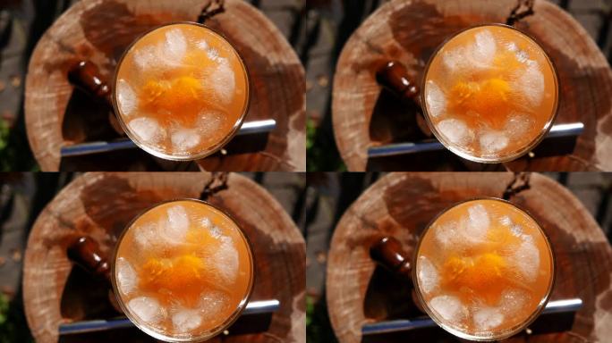 POV:桌上有一杯橘子味的凯匹林纳酒。巴西凯匹林纳酒配甘蔗酒、橘子片、冰块和糖。凯皮林纳酒杯，居高临
