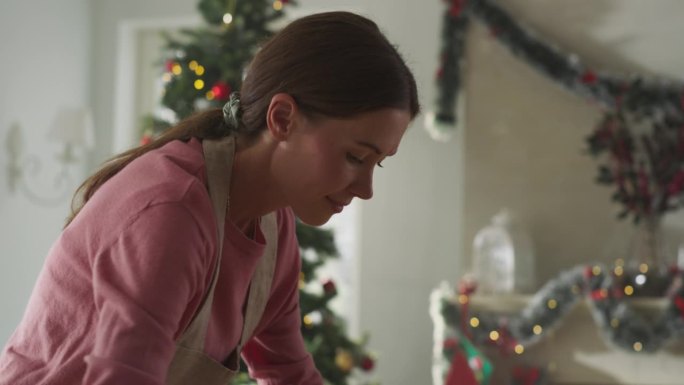 一个美丽的女人准备饼干面团为节日做姜饼的电影镜头。慈爱的母亲为她的家人准备圣诞和新年的糕点