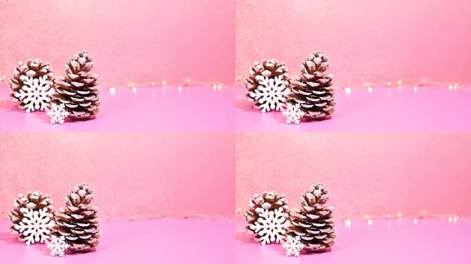 冬季奇思妙想:在闪烁的灯光下，松果和雪花在闪烁的背景中停止运动