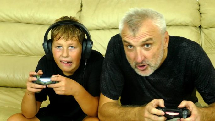 父子俩兴奋地玩着电脑游戏