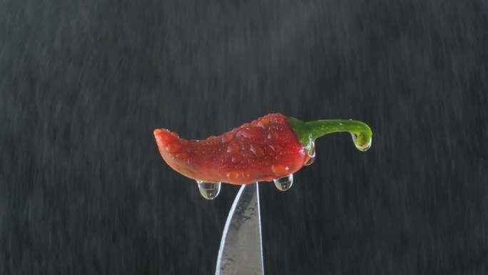 一个美味的红色墨西哥辣椒，放在刀上被洒水