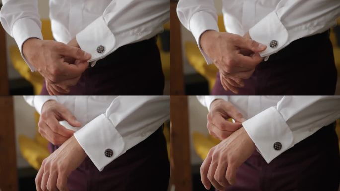 扣西装扣子。婚礼前，手在调整用袖扣系住的衬衫袖口。