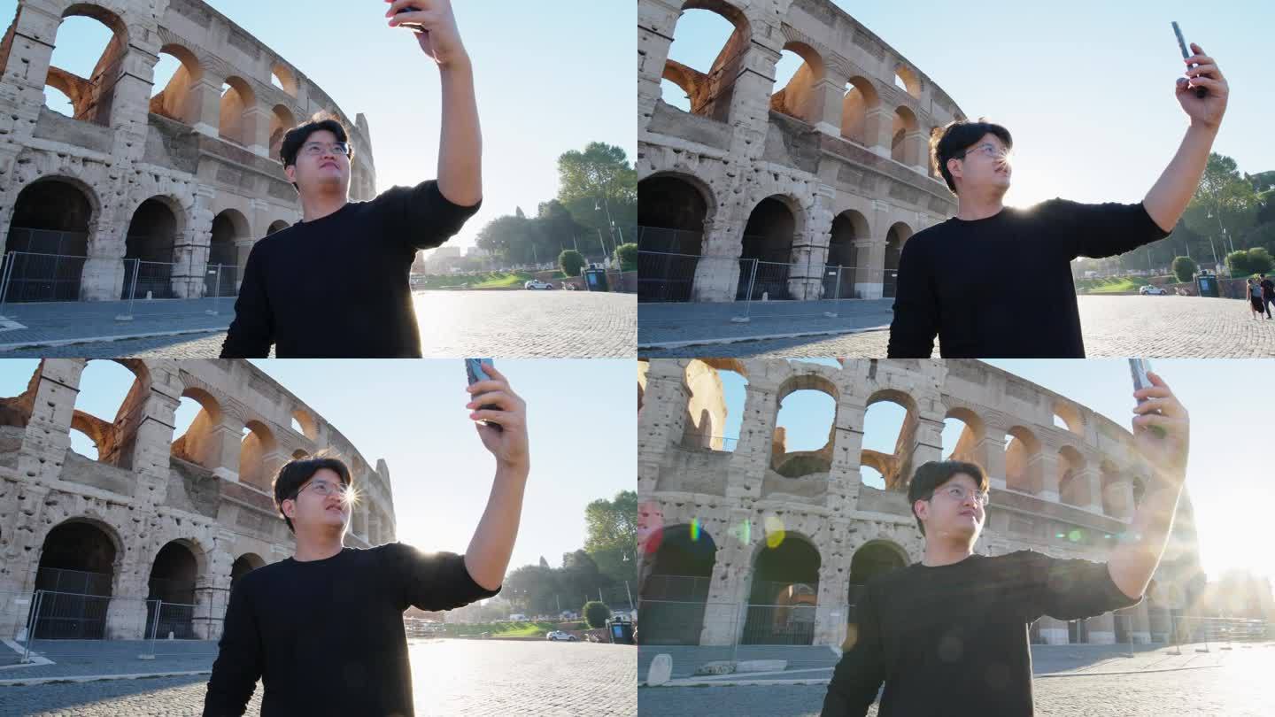 亚洲游客在意大利罗马斗兽场用智能手机自拍，录制视频。