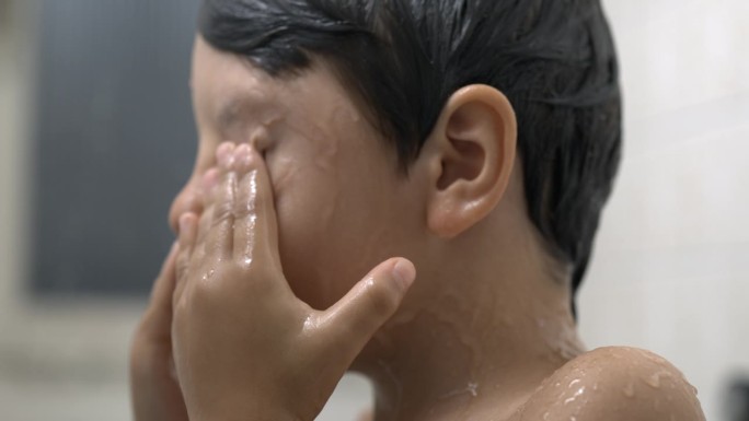 孩子在洗澡时揉眼睛的超级慢动作，特写孩子的脸从眼睛上取下肥皂