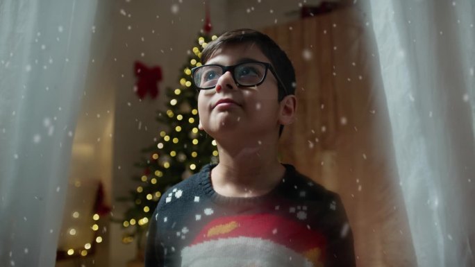 圣诞节时小孩透过窗户往外看