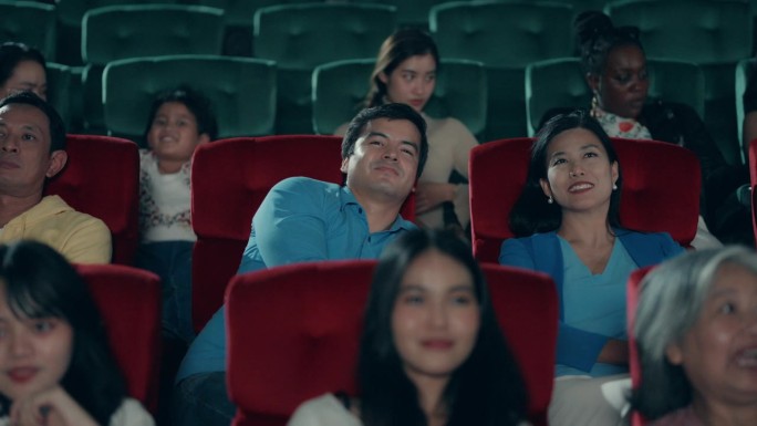一群不同的人在电影院笑着欣赏电影。