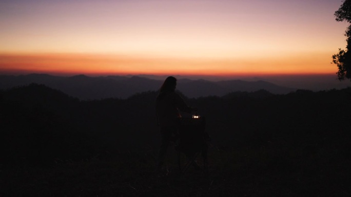 徒步女呆在山上，在日出的时候拍照，有一个快乐的时间