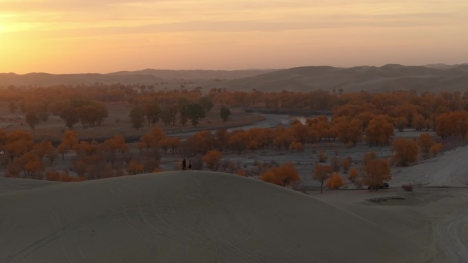 航拍摄影师站在新疆罗布湖景区的沙丘上