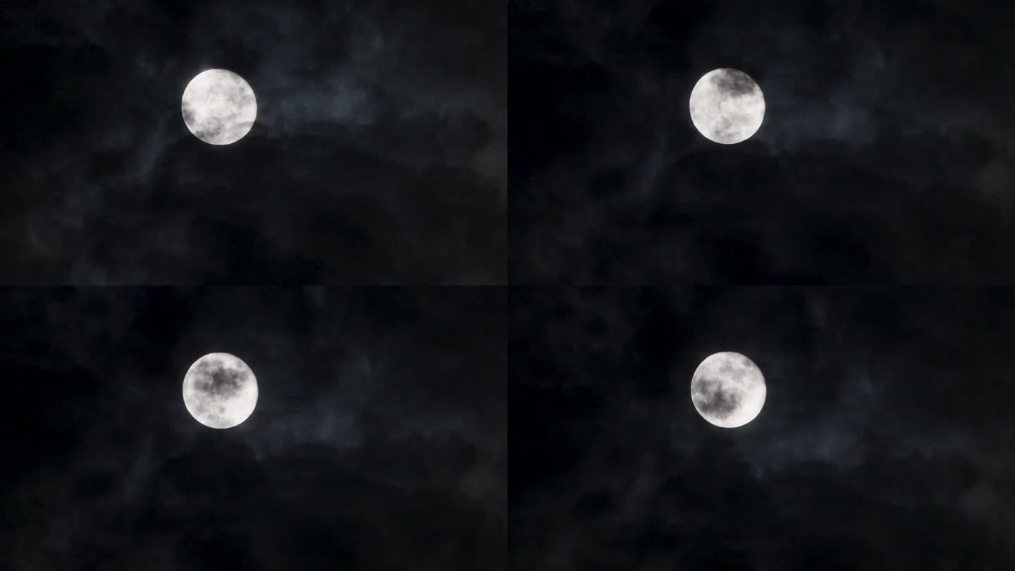 一轮明月挂在天上，有云彩从月亮表面飘过