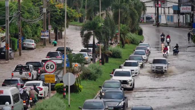 在被水淹没的道路上行驶的车辆。