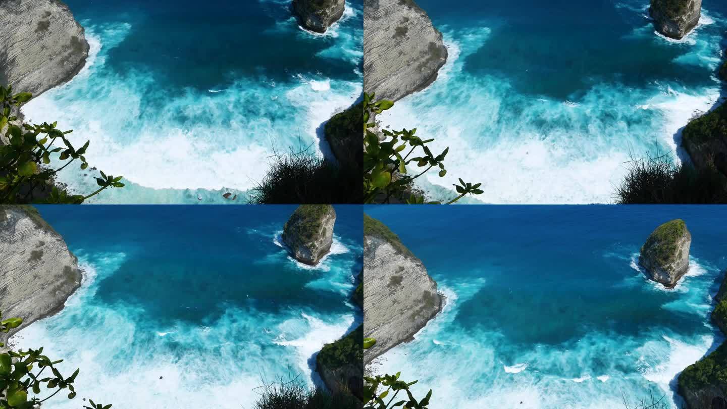 蓝绿色的海洋海水白色的波浪溅深蓝色的大海。鸟瞰怪物波浪飞溅在岩石上。热带海滩在夏季海边户外。大洋岛风