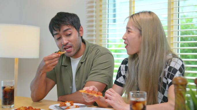 年轻夫妇吃炸鸡和披萨