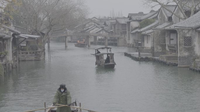 雪中的乌镇河上的乌篷船