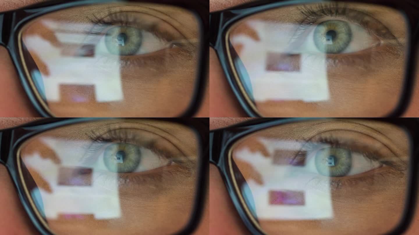 美女的眼睛看着电脑显示器。她眼镜上的倒影。关闭了。