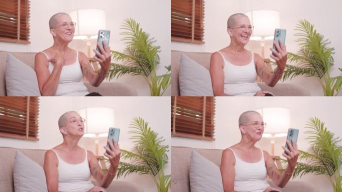 快乐的老女人在沙发上放松，用社交媒体发视频