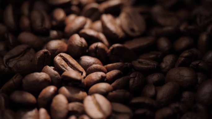 咖啡豆。镜头的特写镜头向上平移，在阳光的阴影下显示烘焙的咖啡豆