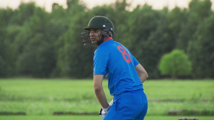 印度职业板球运动员用球棒击球。蓝队击球手成功将球击出外场并跑动得一分。板球运动员正在为冠军而练习