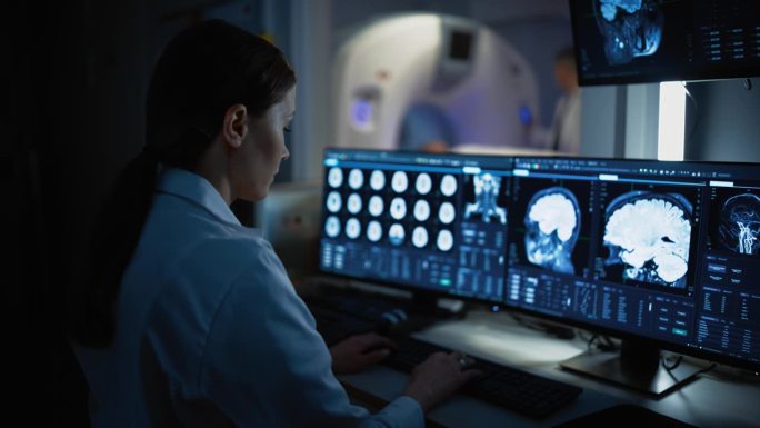 医院研究实验室:女医学家使用计算机与脑扫描MRI图像的病人在后台进行医疗过程。医疗保健服务