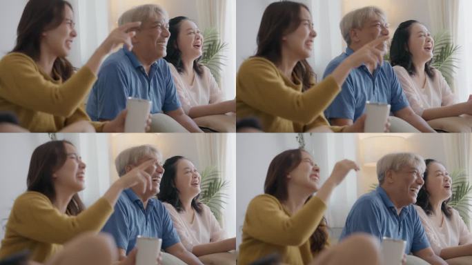 幸福的亚洲多代家庭，祖父母花时间在一起，三代人一起玩，坐在沙发上。