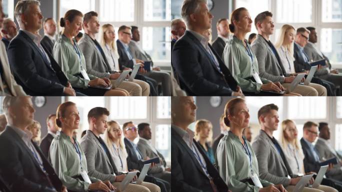 在商务会议上，一位年长的白人女性坐在拥挤的听众中。女高级经理微笑着使用笔记本电脑。专家观看关于投资创