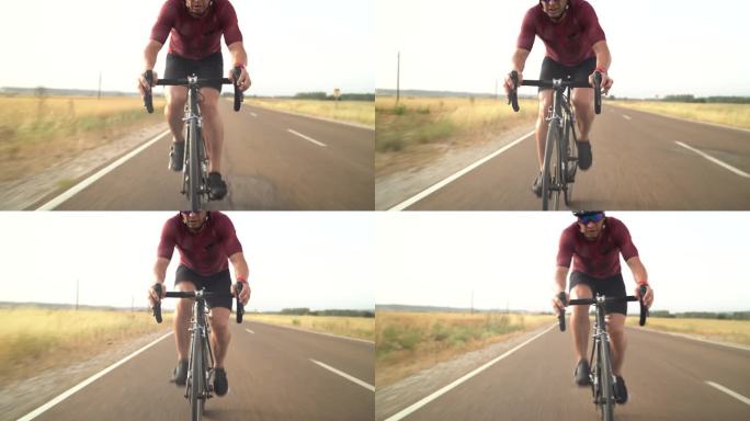 一个骑自行车的成年男子在乡村公路上骑自行车时加速——成年人骑自行车的视频