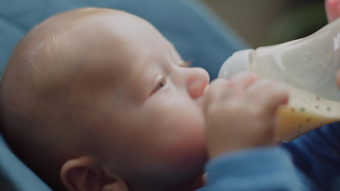 小男孩吸吮一瓶牛奶，小孩子吃，婴儿食品概念
