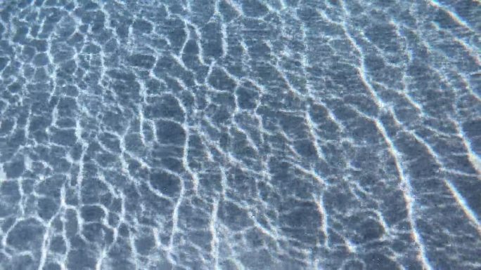 泳池湛蓝透明的水面泛起涟漪，近距离拍摄4K动态场景