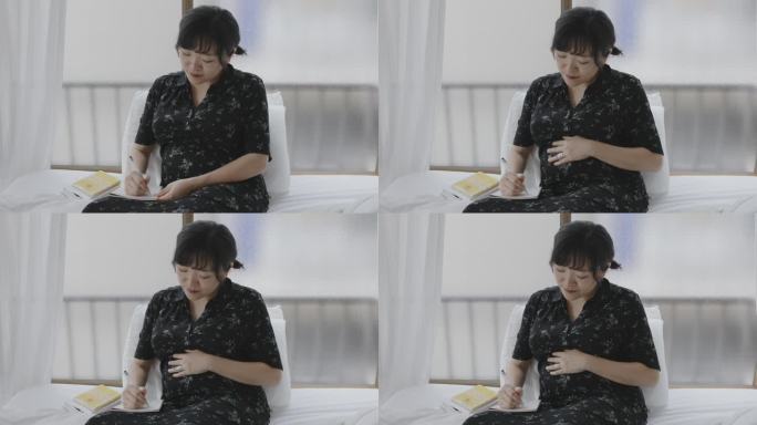 年轻的日本妇女正在写她的怀孕日记